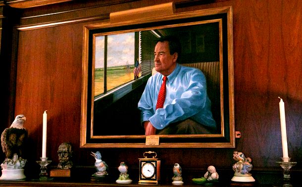写真・図版 : パット・ブキャナン氏の自宅に飾られた自身の肖像画。1992年大統領選の共和党のアイオワ州党員集会の際、バスに乗って選挙キャンペーンをしている姿が描かれている＝ランハム裕子撮影