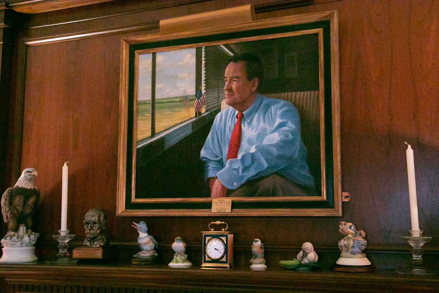 写真・図版 : パット・ブキャナン氏の自宅に飾られた自身の肖像画。1992年大統領選の共和党のアイオワ州党員集会の際、バスに乗って選挙キャンペーンをしている姿が描かれている＝ランハム裕子撮影