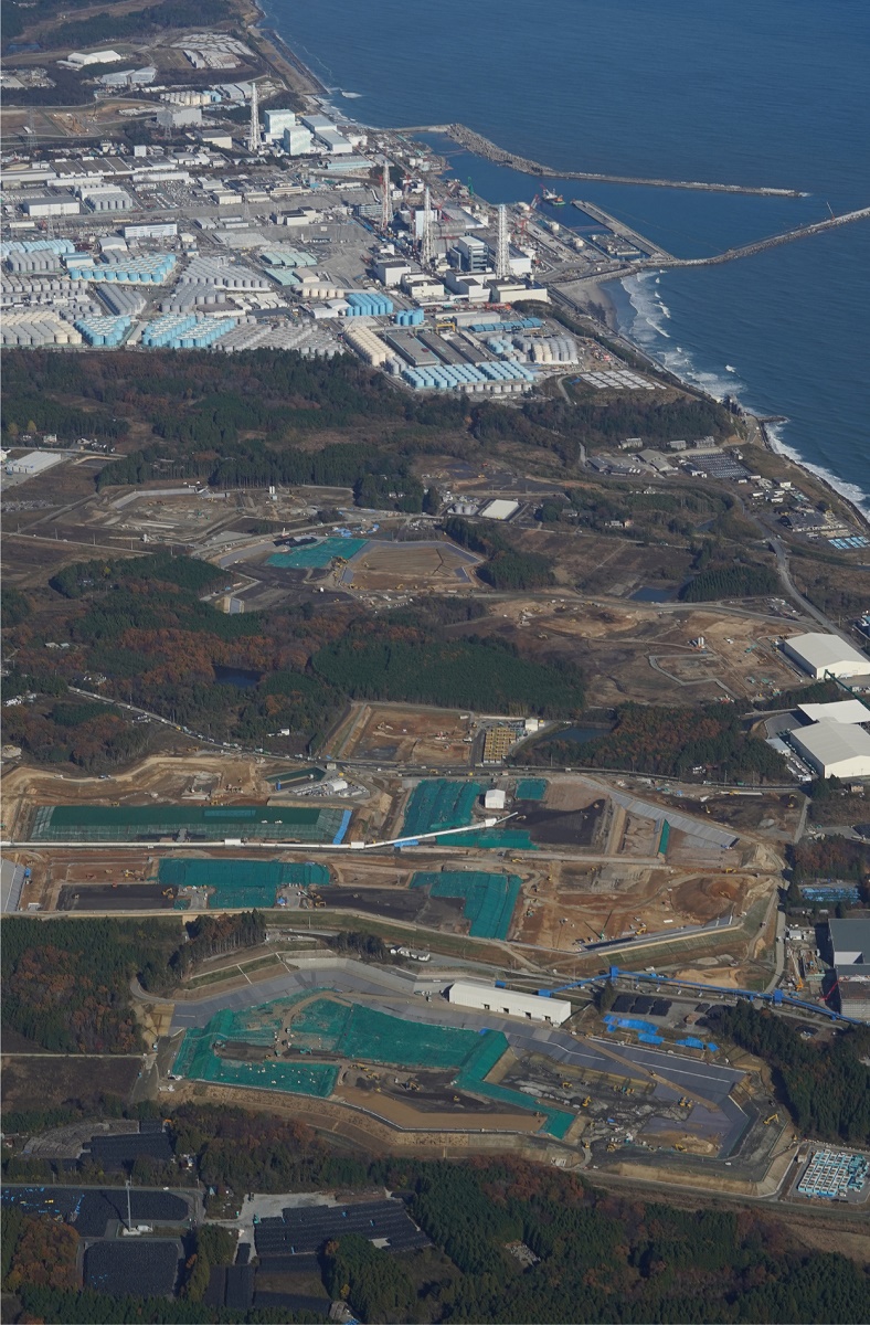 写真・図版 : 写真上方は福島第一原発。手前に広がるのが建設中の中間貯蔵施設＝2019年11月29日
