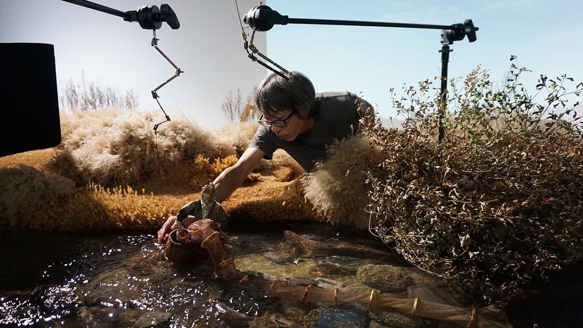 写真・図版 : はりきり網を引き上げる兵十を動かす八代健志監督。セット内に本物の水を使用して川と水流を作り出している