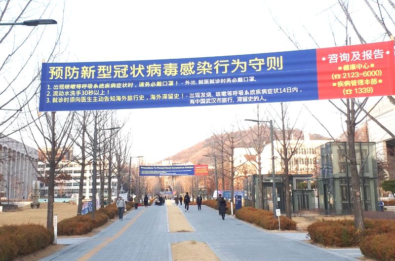 写真・図版 : 韓国・ソウルの延世大学構内では韓国語に加え、英語や中国語でも新型コロナウイルス感染の予防を呼び掛ける横断幕がかかっていた。学生はほぼ全員マスクをしていた＝2020年2月27日