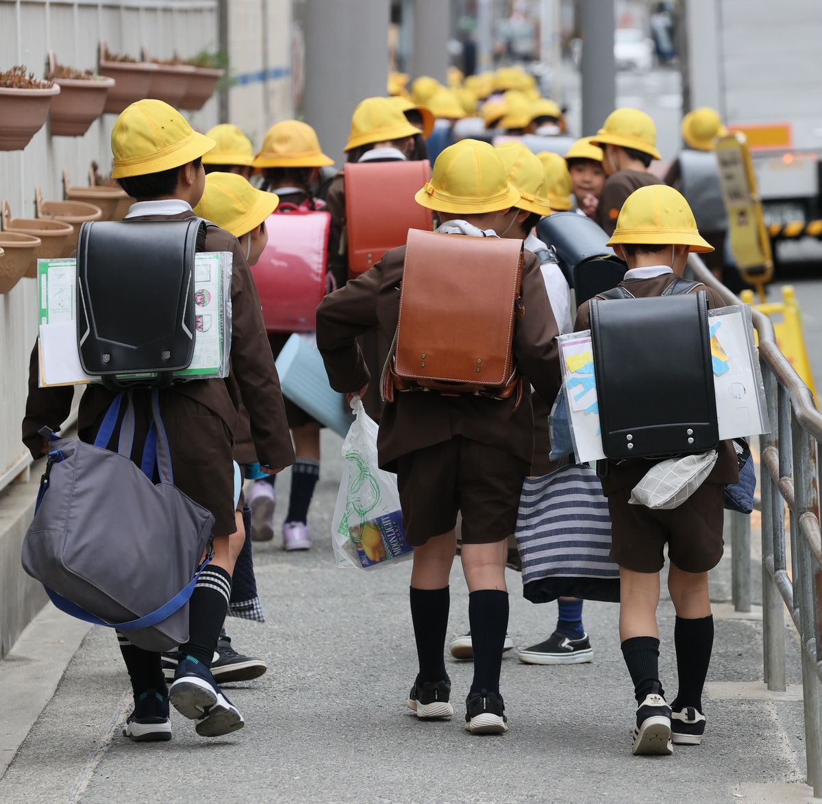 写真・図版 : たくさんの荷物を背負って下校する小学生＝2020年2月28日、大阪市西区