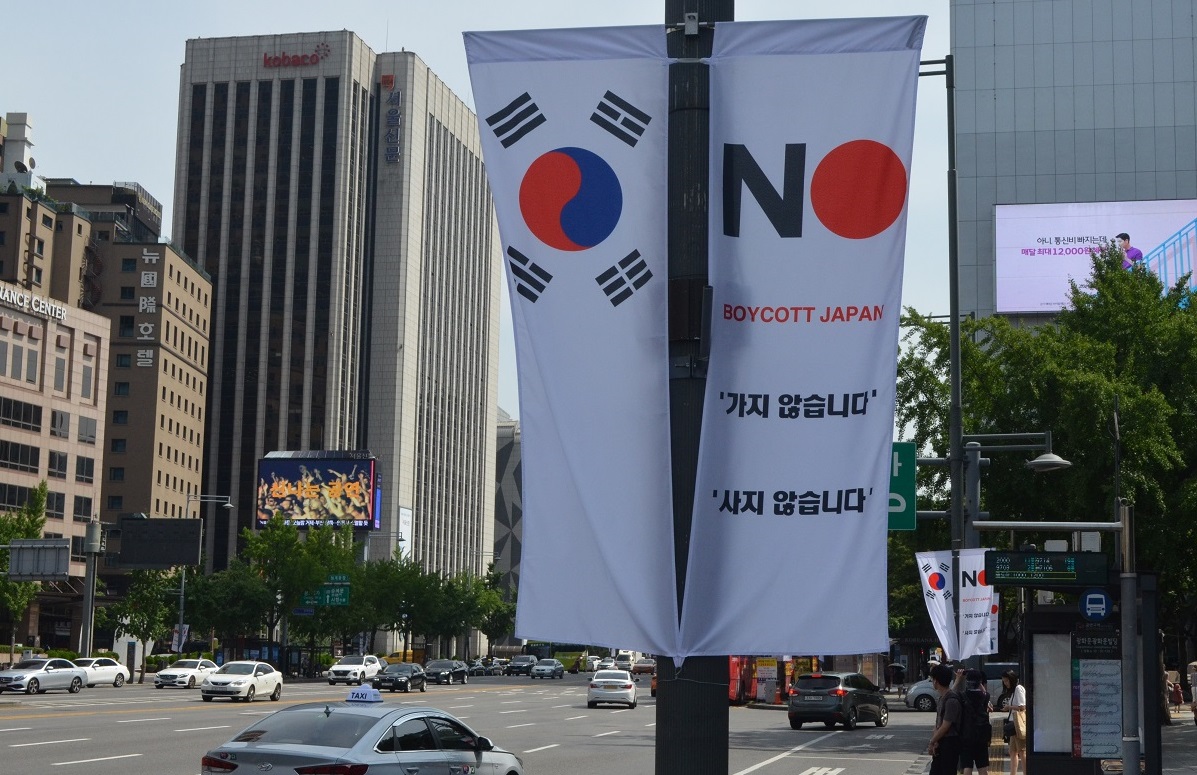 写真・図版 : ソウル市の街頭に一時設置された「BOYCOTT JAPAN(ボイコット日本)」の旗。『反日種族主義』にある「両国の自由市民の連帯」のために必要なこととは=2019年8月、ソウル市中区