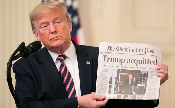 写真・図版 : ホワイトハウスでの演説中、「トランプが無罪に」と大きく書かれたワシントンポスト紙を掲げるトランプ大統領＝ワシントン、ランハム裕子撮影、2020年2月6日