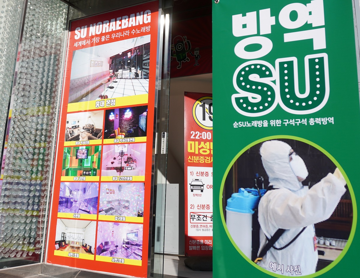 写真・図版 : ソウルのカラオケボックス店の前には、店内を消毒していることを示す表示が出ている=2020年3月11日