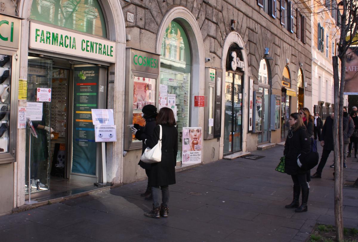 写真・図版 : 距離を置いて薬局に並ぶ人々＝2020年3月10日、ローマ
