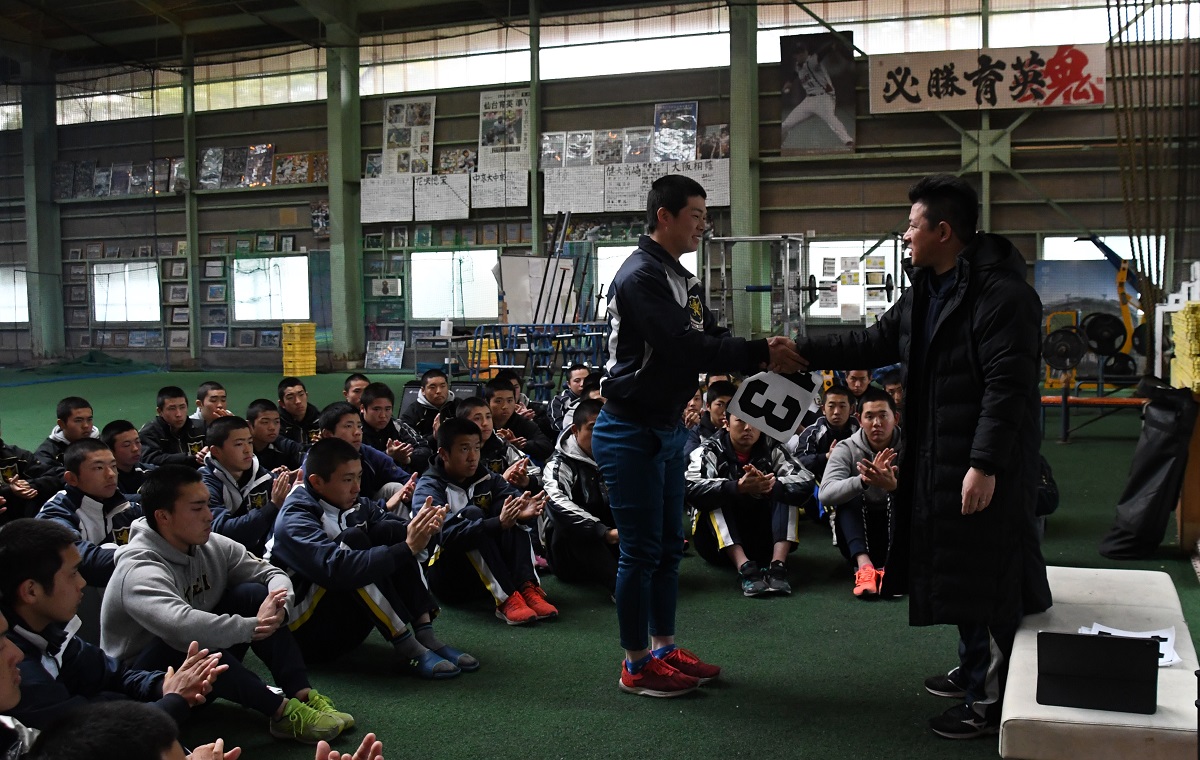 須江航監督（右）が選手一人ひとりに背番号を手渡し、握手した＝宮城県多賀城市20200312