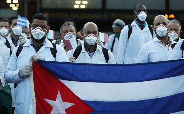 写真・図版 : 新型コロナウイルス治療を支援するためキューバからイタリア・ミラノの空港に到着した医療関係者=2020年3月22日/AP 