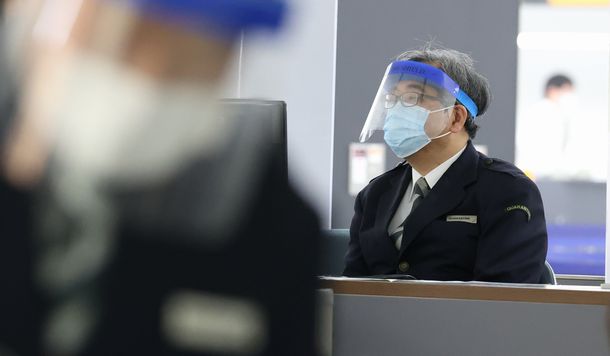 写真・図版 : 検疫検査場で到着客に対応する検疫官＝2020年3月21日、成田空港