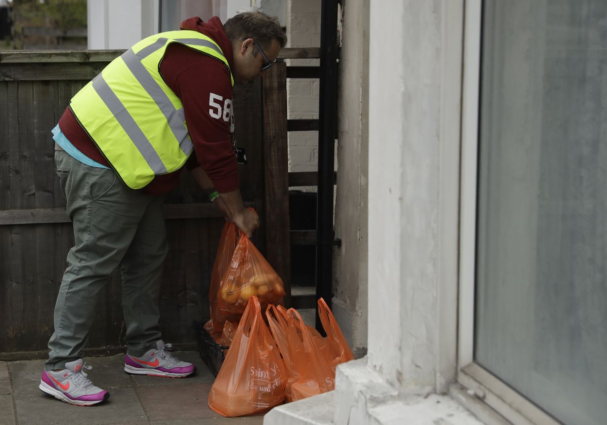 写真・図版 : イギリスのロンドン北部では、慈善団体が寄付された食料や生活必需品が生活弱者に届けられている＝2020年4月1日、AP
