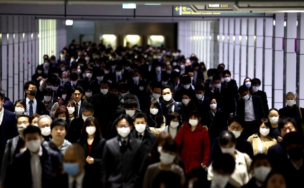 写真・図版 : マスク姿で通勤する人たち＝2020年3月23日、東京都新宿区
