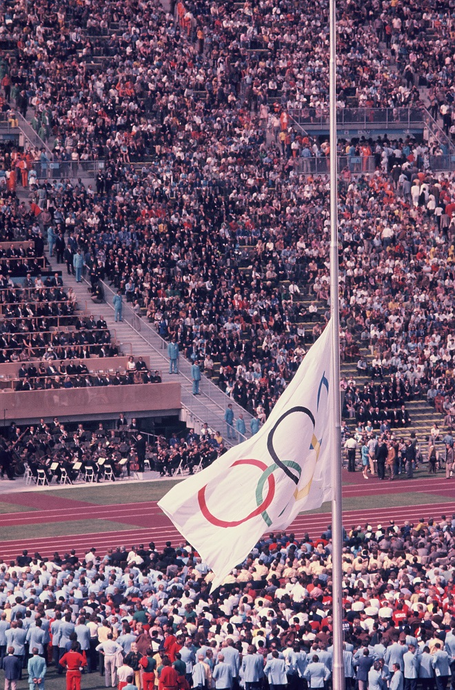 写真・図版 : イスラエル選手2人が殺害された事件の翌日、スタジアムに半旗を掲げて競技は再開された＝1972年9月6日、ドイツ・ミュンヘンのオリンピックスタジアム 
