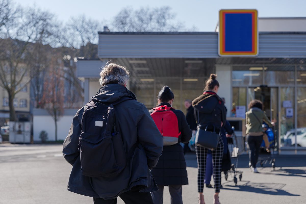 写真・図版 : デュッセルドルフのスーパーの外で並ぶ人たち＝Peeradontax/Shutterstock.com