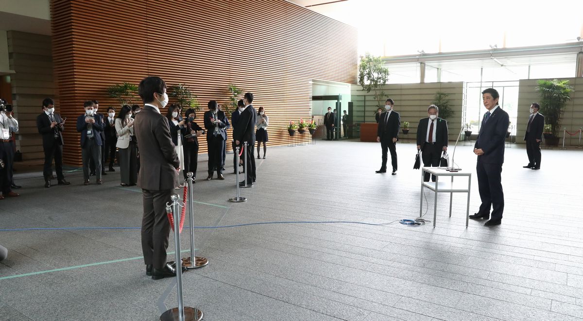 写真・図版 : 緊急事態宣言についての取材にこたえる安倍晋三首相（右）。記者との間が広い＝2020年4月21日午前、首相官邸
