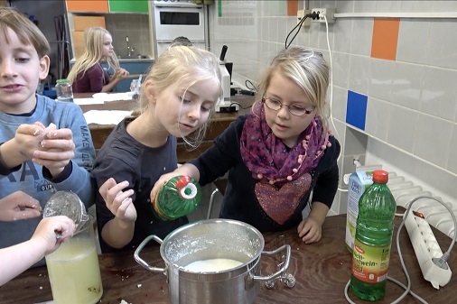 写真・図版 : ドイツの小学校（ニーダーザクセン州：グランドシューレ　ノイハウス　アン　デア　オステ小学校）の授業のシーン。2年生の児童たちが酢と牛乳からプラスチックの代用品を作っていた。