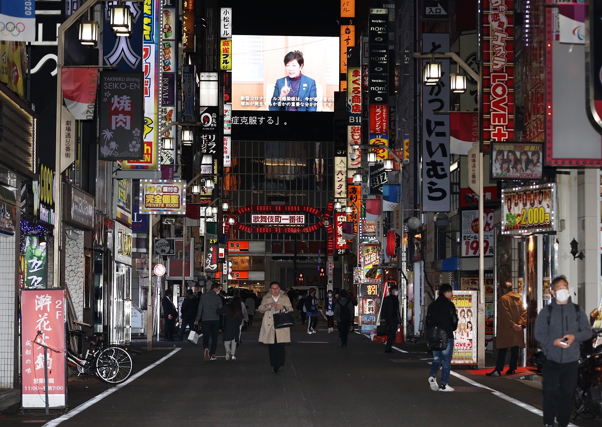 写真・図版 : 人影がまばらな新宿・歌舞伎町の繁華街。奥の大型ビジョンには、外出自粛などを呼びかける東京都の小池百合子知事が映し出されていた＝2020年4月10日