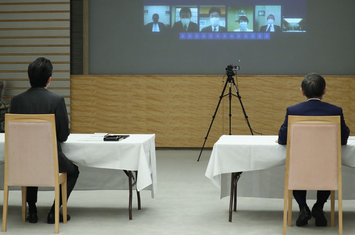 写真・図版 : テレビ会議形式で行われる閣議に臨む安倍晋三首相（左）。右は菅義偉官房長官＝2020年5月1日、首相官邸