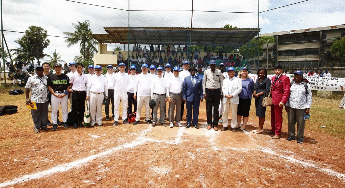 写真・図版 : タンザニア甲子園大会は支援者の協力で成り立つ。中央のスポーツ大臣を囲んで、右方向にマカタタンザニア野球連盟会長、在タンザニア日本大使館後藤大使、アメリカ大使館書記官、ザンジバル野球連盟名誉会長・島岡強氏。左方向に、大阪北ロータリークラブのみなさん、トヨタ通商の田中氏ら。©Teruaki Iida JPS2194