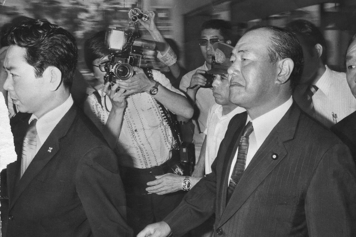 写真・図版 : ロッキード事件で、東京地検は田中角栄元首相に対し、外国為替及び外国貿易管理法違反の疑いで検察合同庁舎への任意同行を求め、取り調べ後に逮捕状を執行した。写真は、東京地検から東京拘置所へ向かう田中元首相＝1976年7月27日