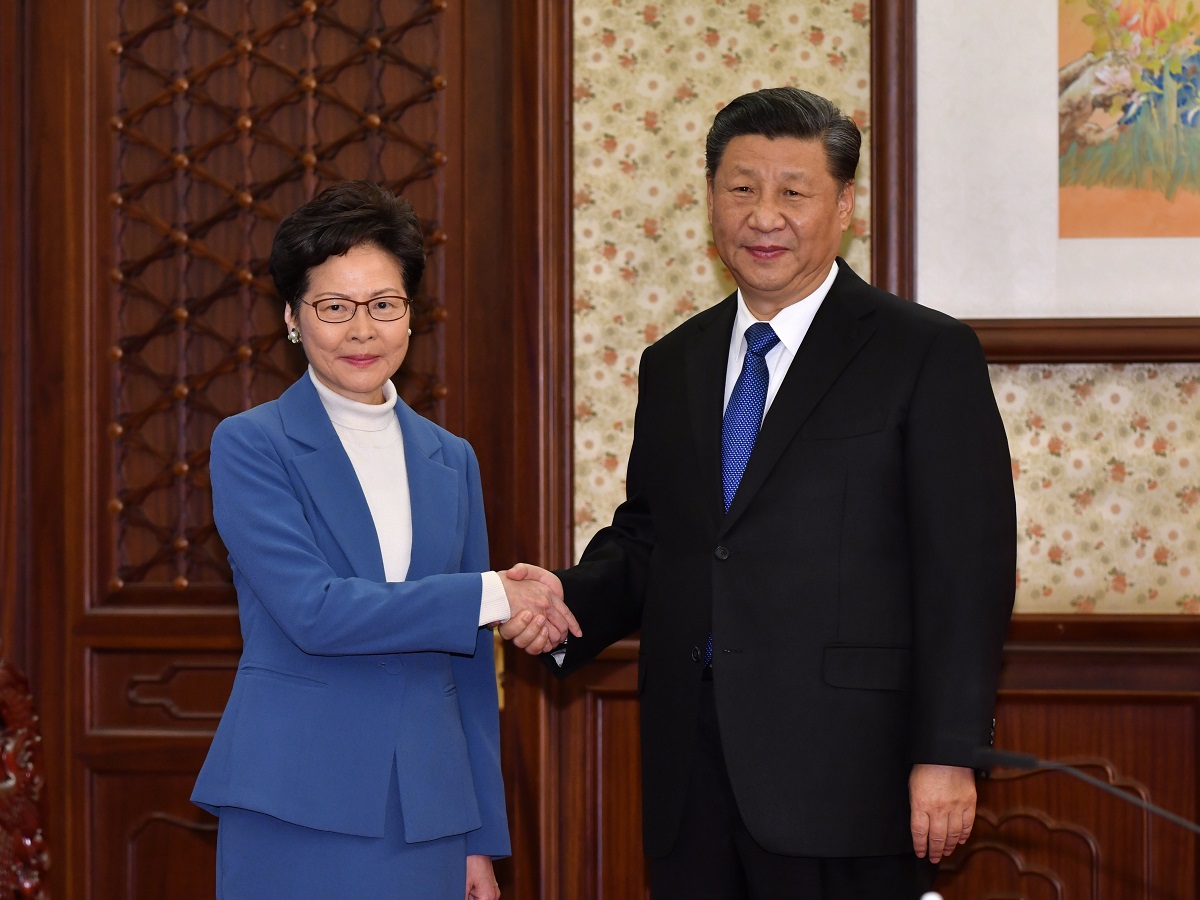 写真・図版 : 中国の習近平国家主席（右）と握手する香港の林鄭月娥行政長官＝2019年12月16日、北京、香港政府提供