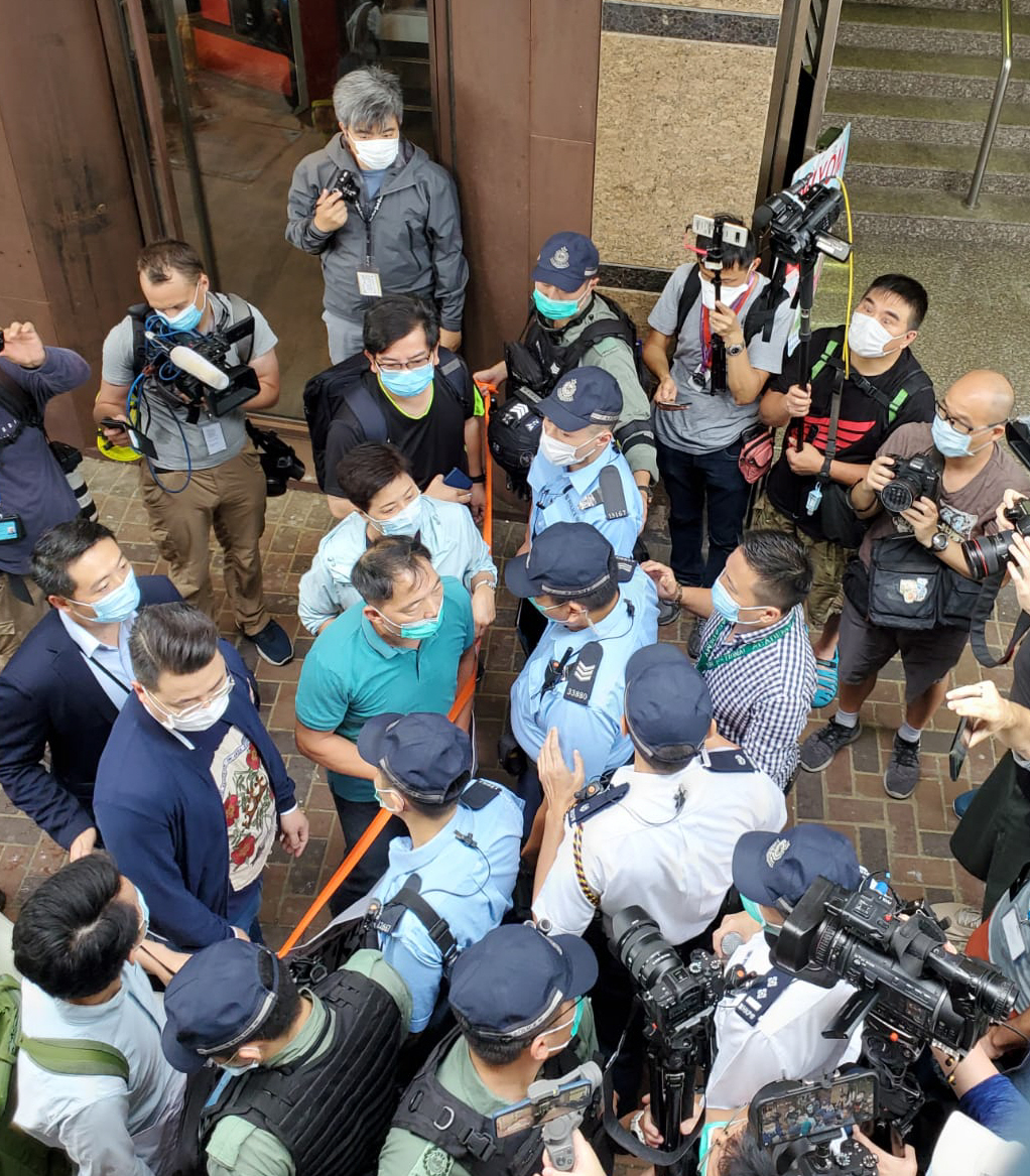 写真・図版 : 香港で2020年5月22日、民主派（左）のデモ行進をテープを張って遮る警官隊