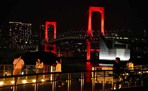写真・図版 : 警戒を呼びかける「東京アラート」で赤色にライトアップされたレインボーブリッジ＝2020年6月2日、東京都港区、恵原弘太郎撮影 