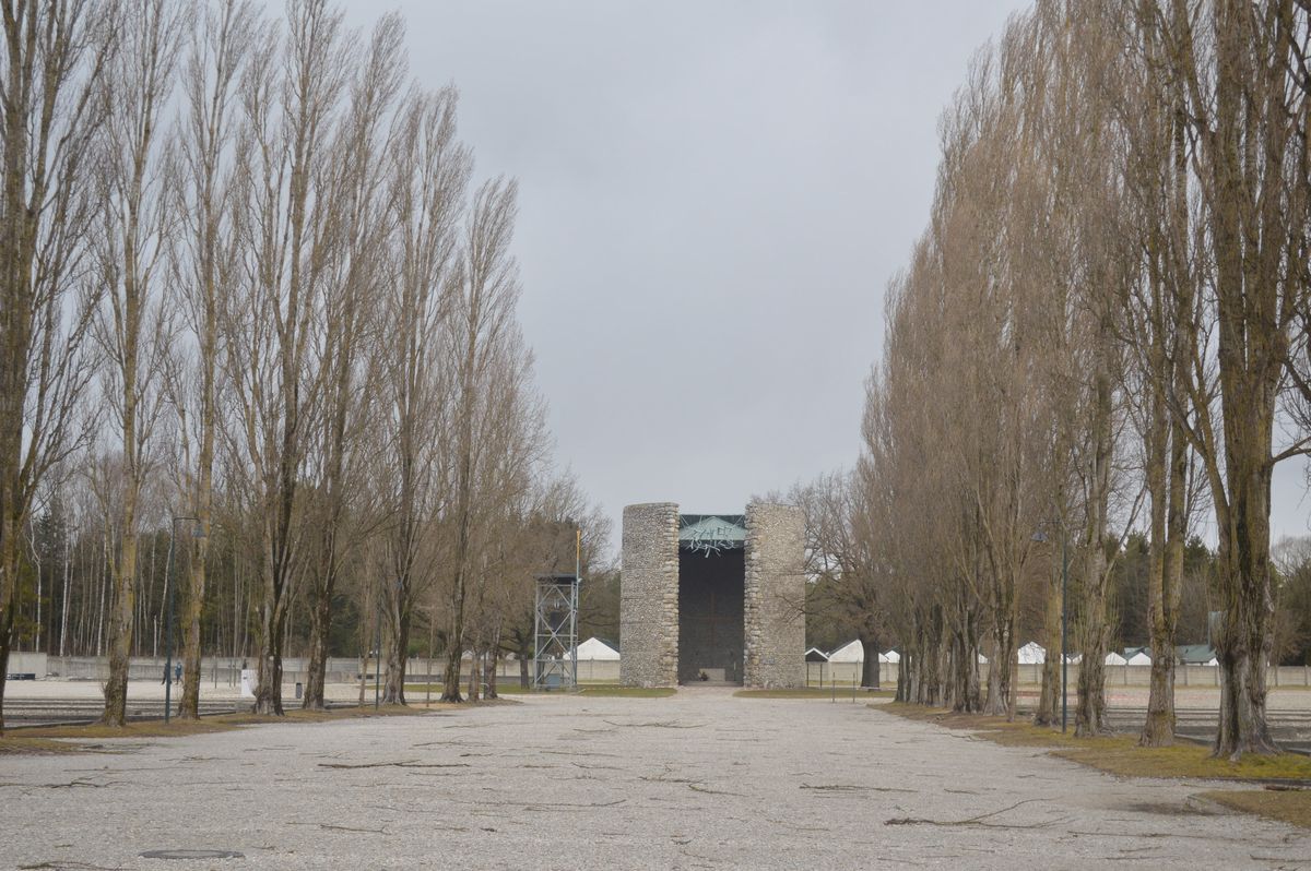 写真・図版 : ドイツ・ダッハウの強制収容所跡のポプラ並木。奥は戦後できた教会