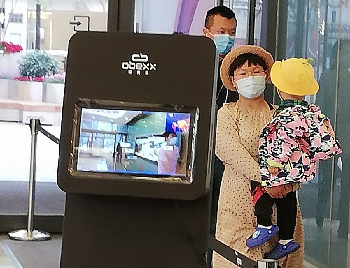 写真・図版 : 北京市内の商業施設。入る際には自動検知器で体温を測る＝2020年5月6日、平井良和撮影 