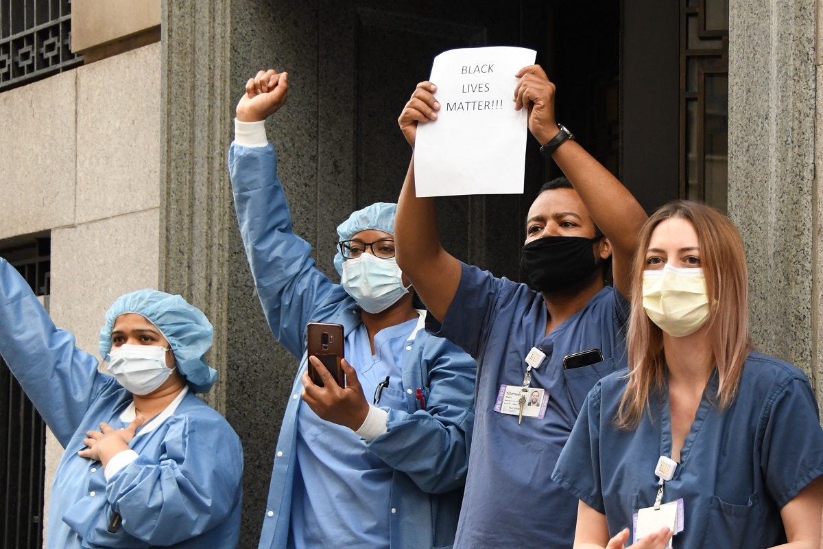 写真・図版 : デモに賛意を示す医療従事者=2020年6月2日、ニューヨーク
