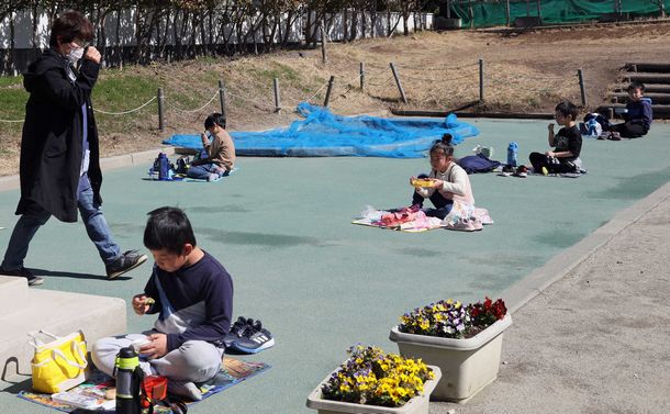 写真・図版 : 休校中の子らに昼食を支援した山梨県の児童センターでは、屋外で一人ずつ離れて食べていた＝3月9日、河合博司撮影