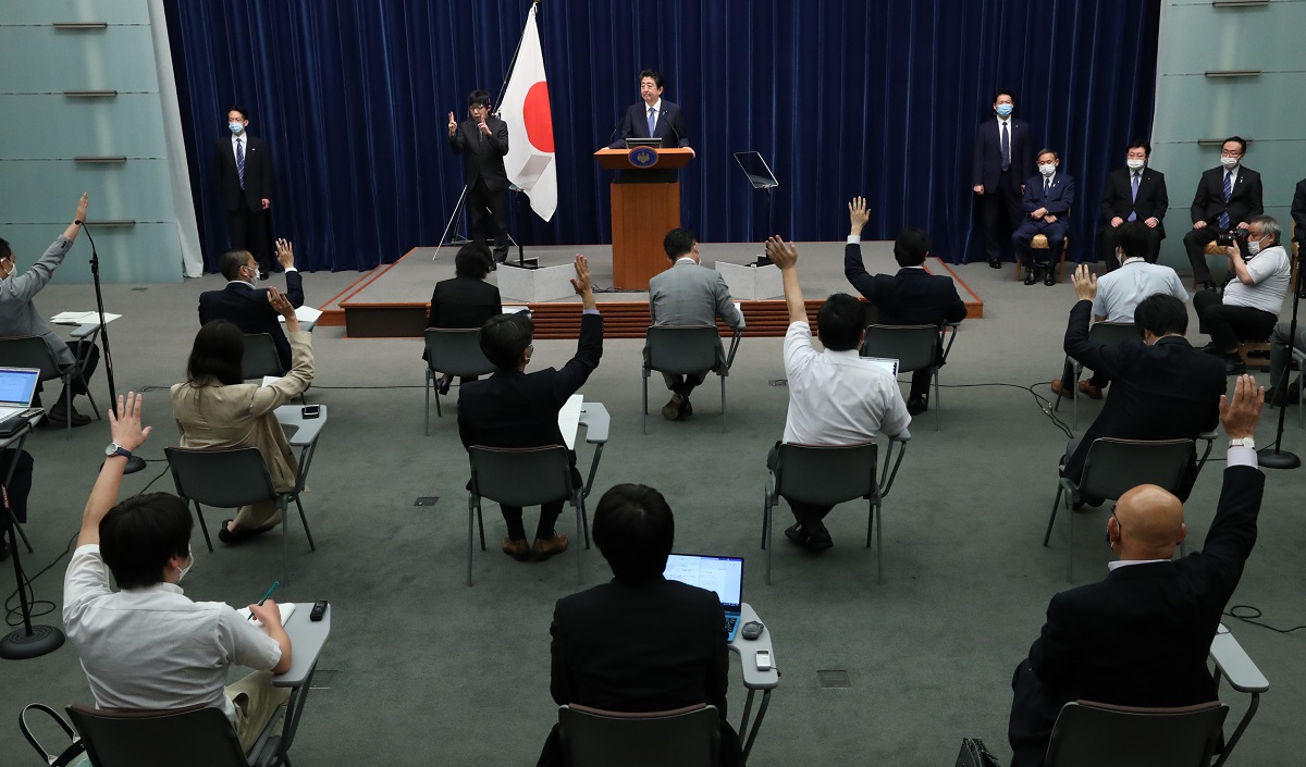 写真・図版 : 安倍晋三首相(中央上)の会見で挙手をする記者たち=2020年6月18日
