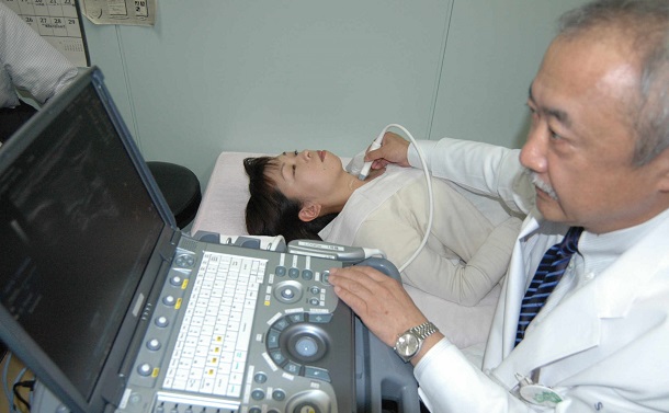 写真・図版 : 公開された検査のリハーサルで、医師は大学職員の首に甲状腺の超音波検査装置をあてた＝2011年10月8日、福島市光が丘の福島県立医科大 