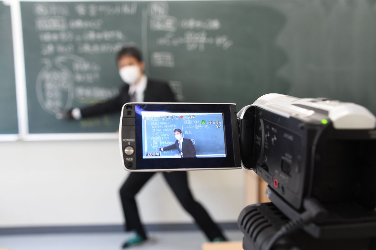 写真・図版 : カメラに向かって数学の問題を解説する広島皆実高校の教諭＝2020年5月1日、広島市南区