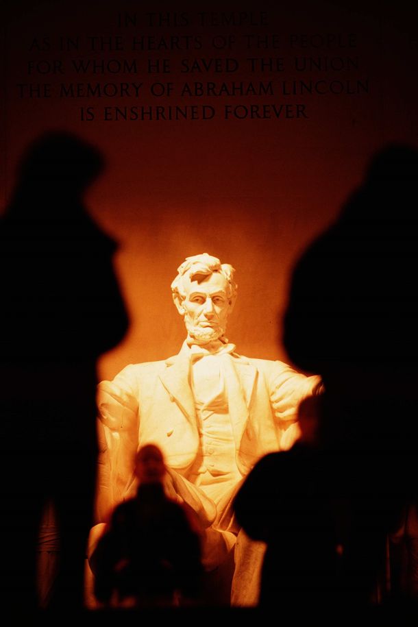 写真・図版 : リンカーン記念堂にあるリンカーン像。座像の後ろには「合衆国を救ったリンカーンの思い出は、国民の心とこの霊廟に永遠に刻まれている」との献辞が刻まれている。（山本和生撮影）