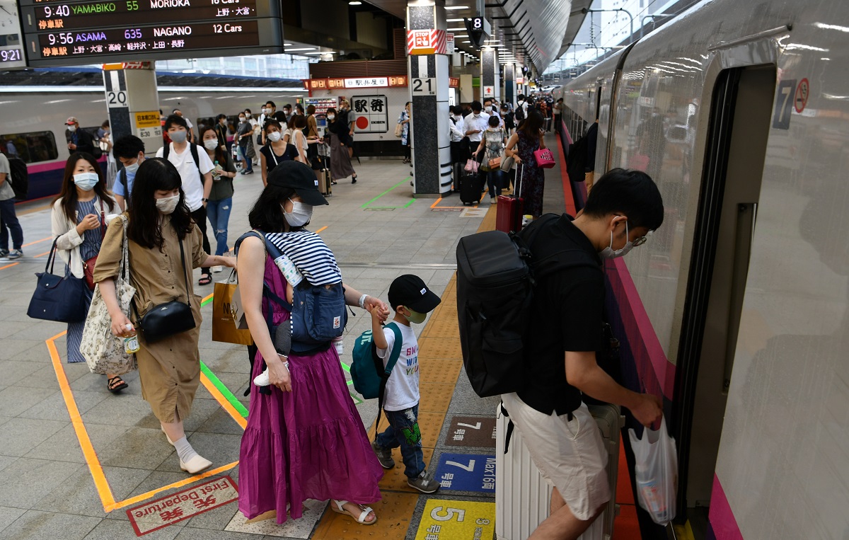 マスクをつけ新幹線に乗り込む家族連れ=2020年7月23日午前9時21分、JR東京駅

