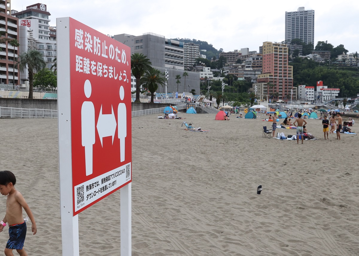 写真・図版 : 海岸でも感染防止を呼びかける看板が設置されていた=2020年7月23日、静岡県熱海市の熱海サンビーチ