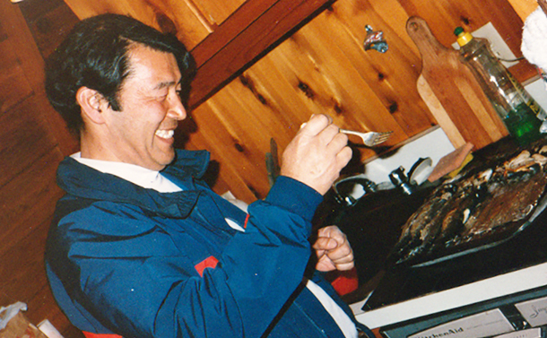 写真・図版 : 釣り上げたニジマスを調理する小西正一さん＝1987年、藤田一郎教授提供