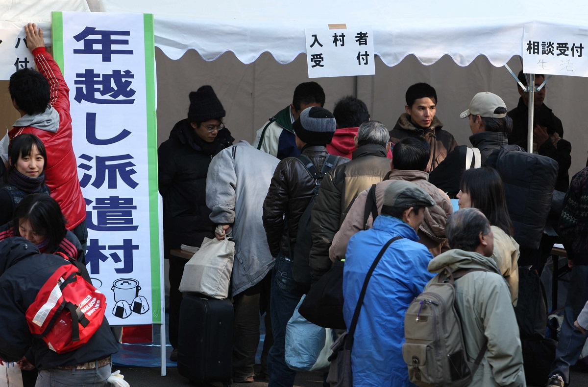 写真・図版 : 「年越し派遣村」に設置された入村手続きのためのテントには長い行列ができた＝2008年12月31日、東京・日比谷公園 
