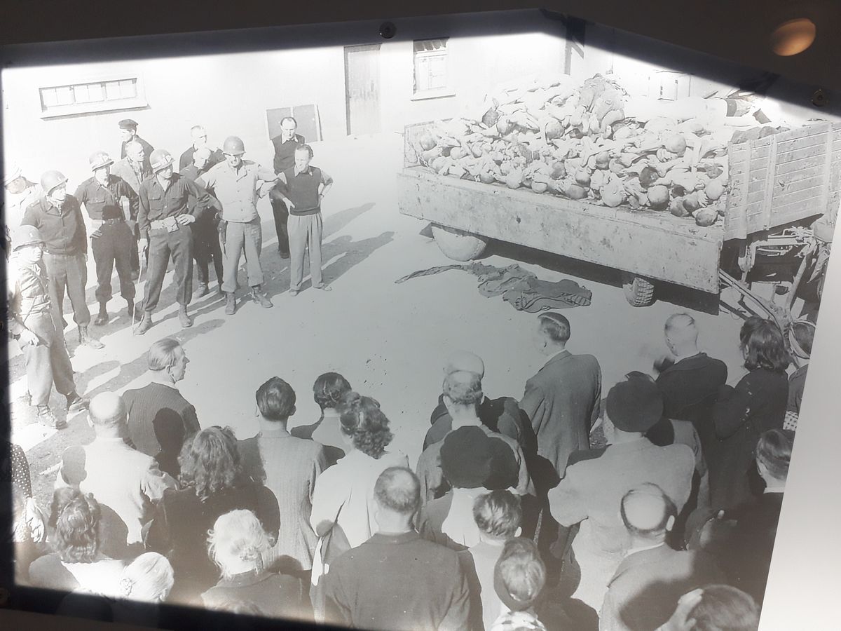 写真・図版 : 常設展の展示写真。説明によると米陸軍撮影で、米軍が解放後のブッヘンバルト強制収容所にワイマール市民を呼び、遺体焼却場を見せている=2月、ドイツ・ワイマール