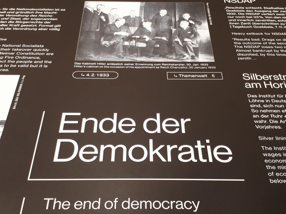 写真・図版 : 「民主主義の終わり」の展示。上には1933年にヒトラーが首相になった頃の写真がある