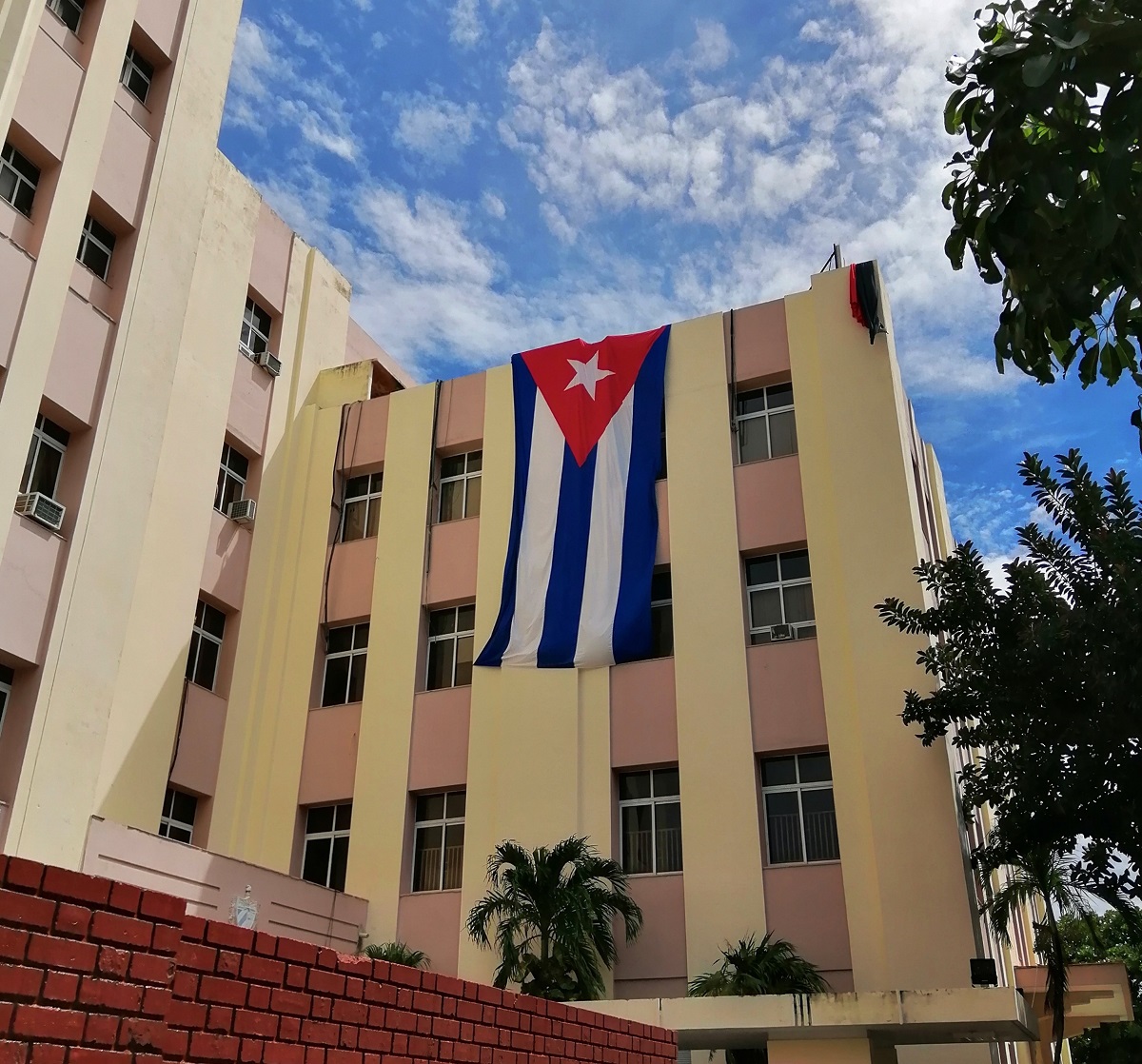 写真・図版 : 革命記念日の7月26日、役所に翻るキューバ国旗=撮影・筆者