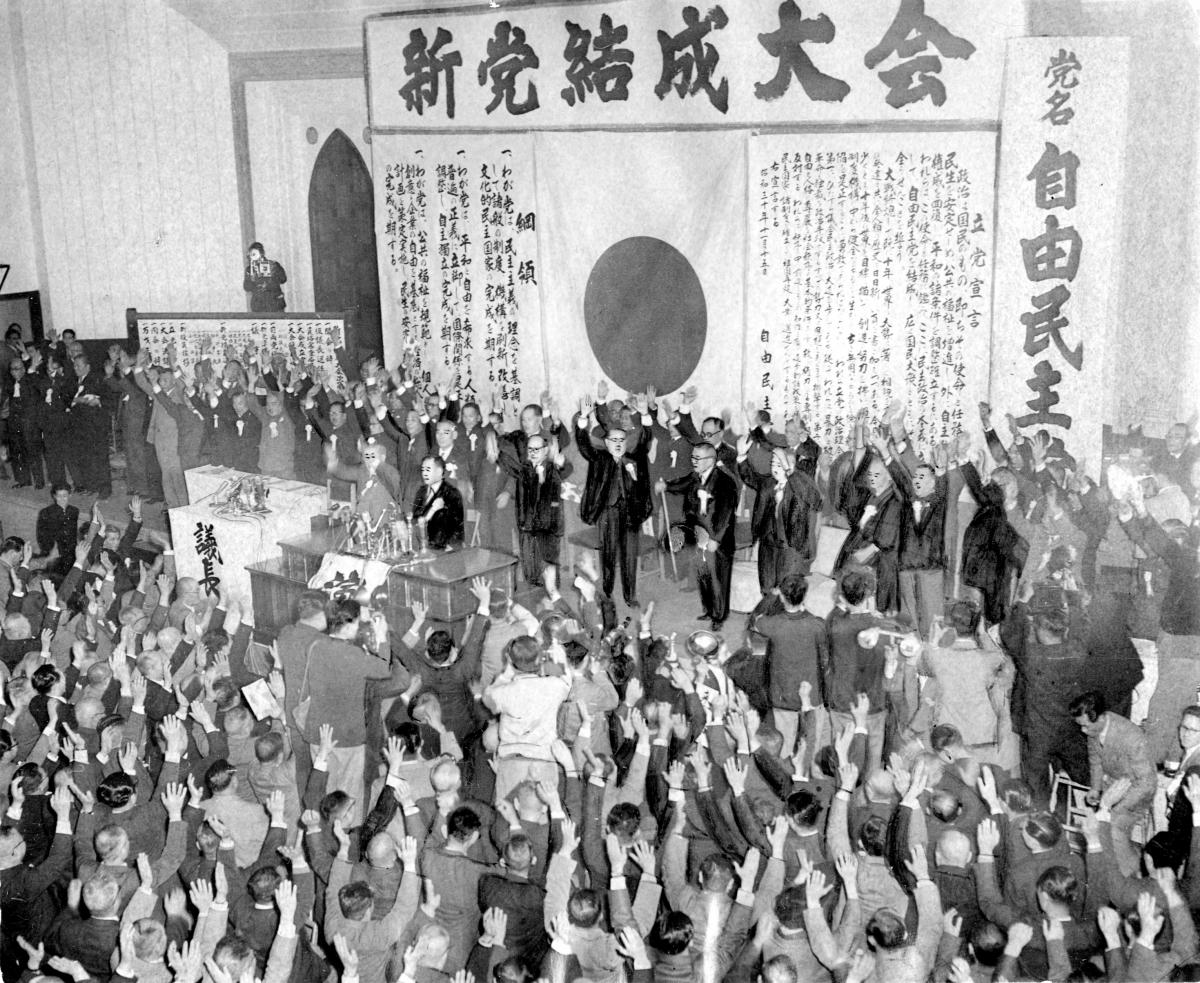 写真・図版 : 3カ条の「綱領」が掲げられた自民党の結党大会＝1955年11月15日、東京・神田 
