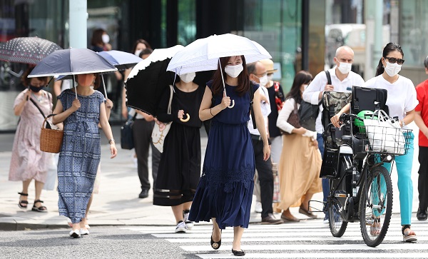 写真・図版 : 猛暑の中でもほとんどの人がマスクをつけている＝2020年8月7日、東京都中央区、藤原伸雄撮影 