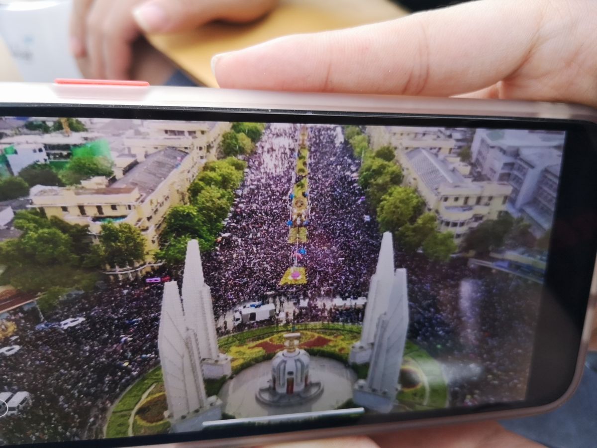 写真・図版 : 「こんなにたくさん来ているよ。数万人はかたい」。反政府集会に参加した学生のひとりが、仲間の間で転送されている写真を見せてくれた＝2020年8月16日、バンコク・民主記念塔前、吉岡桂子