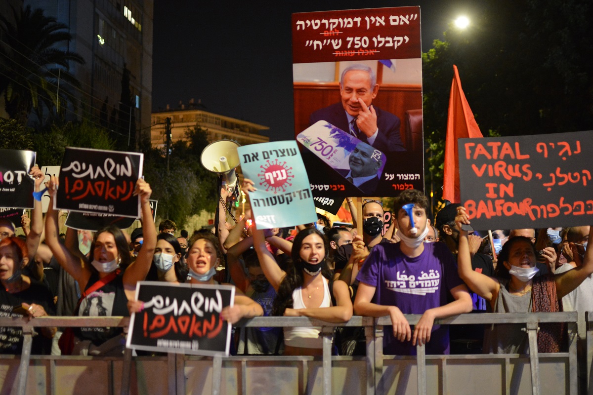 写真・図版 : イスラエルのネタニヤフ首相の公邸前に集まり、退陣を求める若者たち=2020年7月16日、エルサレム