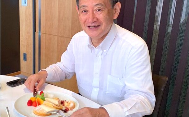 写真・図版 : パンケーキを前に笑顔を見せる菅氏。2万5千件以上の「いいね」がついた＝秋本真利衆院議員のツイッターから 