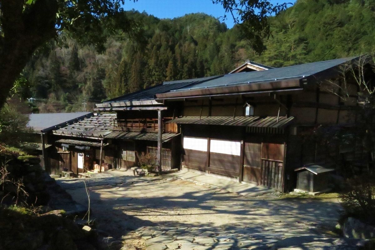 写真・図版 : 枡形跡の近くには石置き屋根なども見られる。背後の山並みと一体に、往時の宿場の風情を醸し出している＝筆者撮影