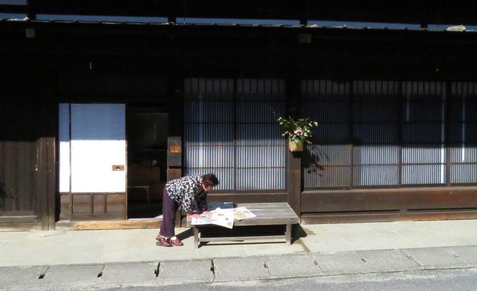 写真・図版 : 今昔が溶け合う妻籠宿の暮らし。竹かごに活けられた花が旅人を迎えてくれるよう＝筆者撮影