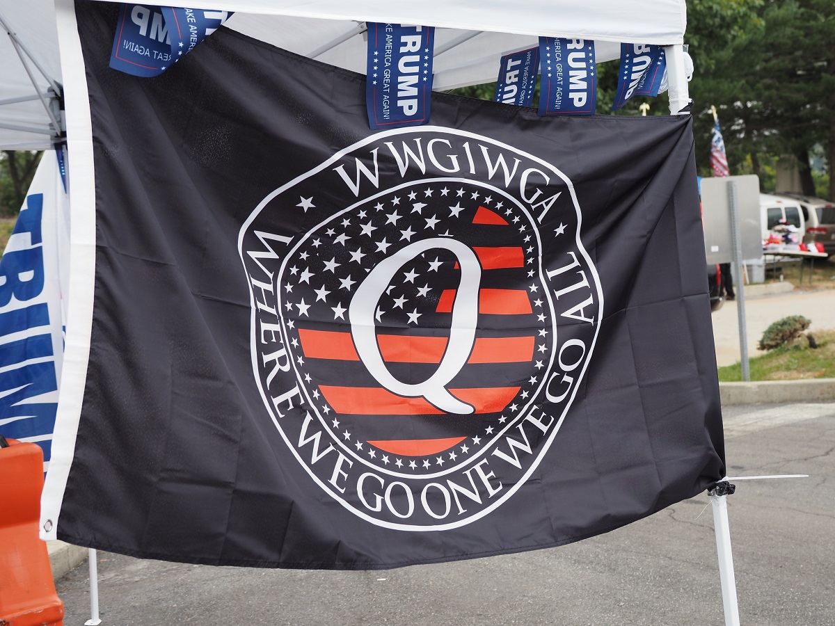 写真・図版 : トランプ大統領の選挙集会の会場周辺で掲げられていたQアノンの旗＝2020年9月26日、米ペンシルベニア州ミドルタウン