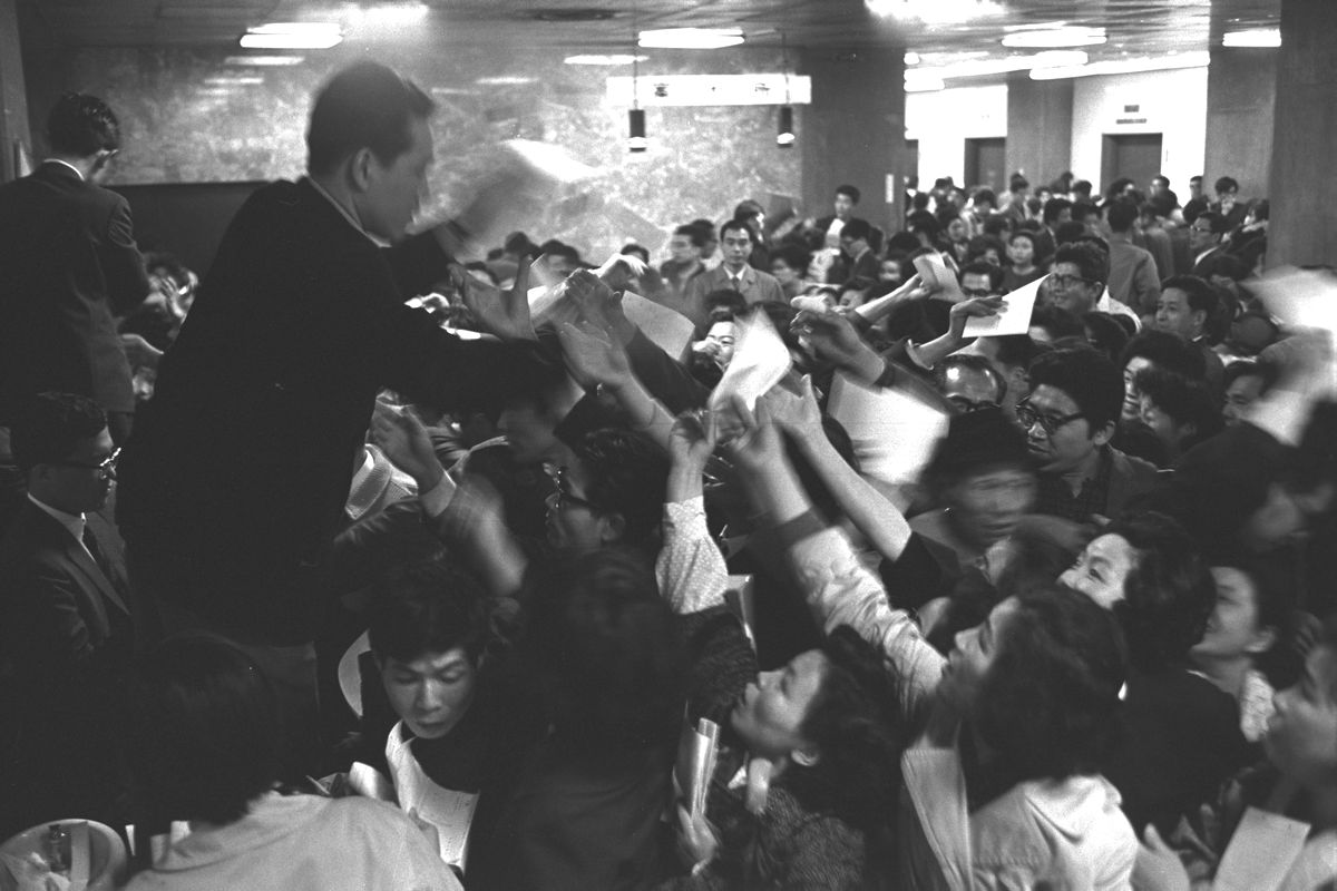 写真・図版 : 都営住宅の空き家募集の受け付けを始めると、初日の午前中だけで2万人が殺到し、パトカーが出動する騒ぎに。写真は大混雑する東京都庁第2庁舎＝1966年4月4日、東京都千代田区丸の内